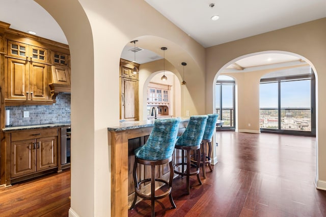 1201 Yale Pl Unit 2303, Minneapolis, MN 55403 - bar with baseboards, dark wood-style flooring, tasteful backsplash, and indoor wet bar