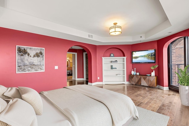 1201 Yale Pl Unit 2303, Minneapolis, MN 55403 - bedroom with wood finished floors, visible vents, baseboards, a raised ceiling, and arched walkways