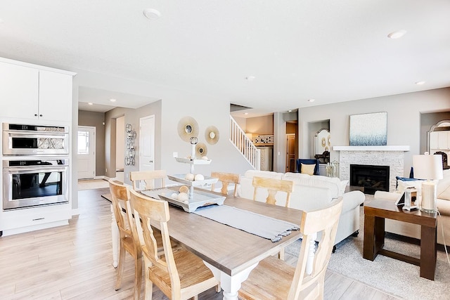 dining area featuring a fireplace and light wood-type flooring