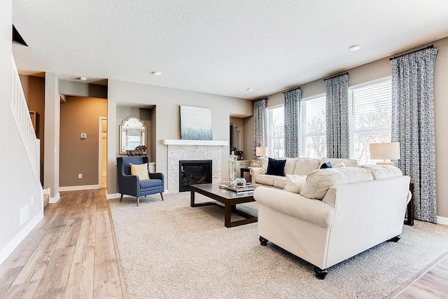 living room with a textured ceiling and light wood-type flooring