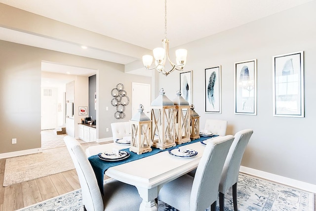 dining space featuring a notable chandelier and light wood-type flooring