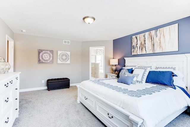 bedroom featuring light carpet and ensuite bathroom