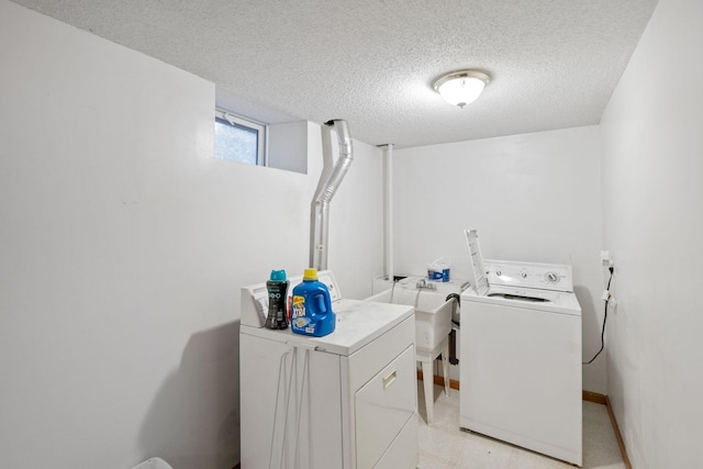 clothes washing area with a textured ceiling and washing machine and clothes dryer