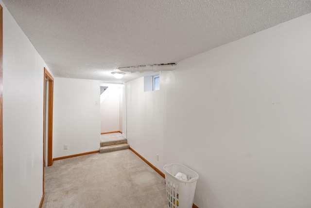 basement featuring a textured ceiling and light carpet