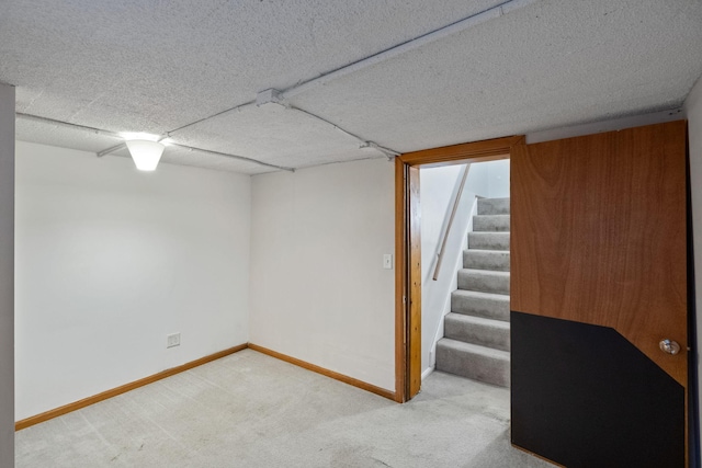 basement featuring carpet floors and a textured ceiling