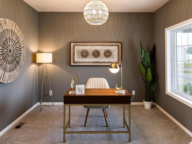 carpeted office space featuring an inviting chandelier