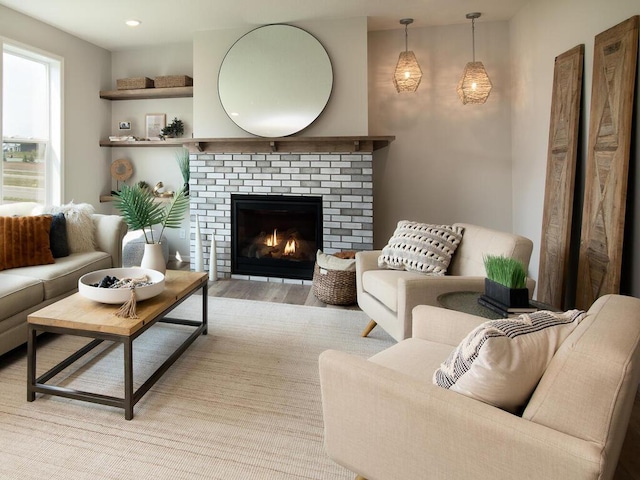 living room featuring a brick fireplace and light hardwood / wood-style floors