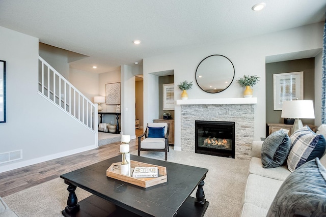 living room with a fireplace, wood-type flooring, and a textured ceiling