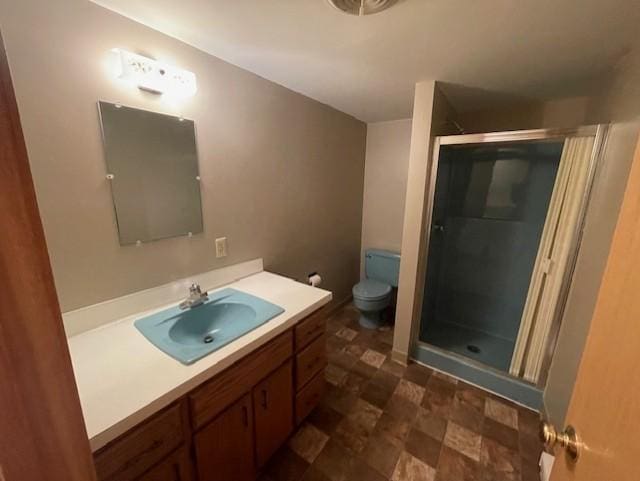 bathroom with an enclosed shower, vanity, and toilet