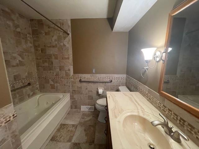 bathroom with tile walls, vanity, and toilet