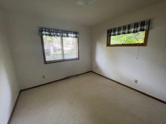 carpeted spare room featuring a healthy amount of sunlight