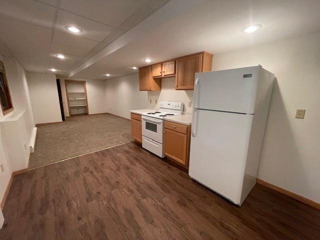 kitchen featuring dark wood-type flooring, white appliances, and a drop ceiling