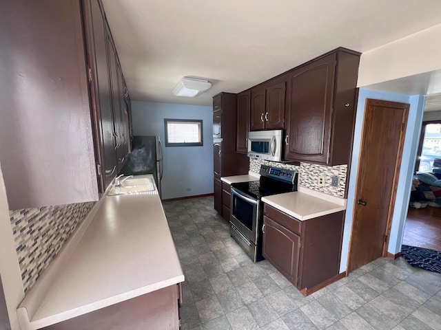 kitchen with stainless steel appliances, dark brown cabinetry, sink, and tasteful backsplash