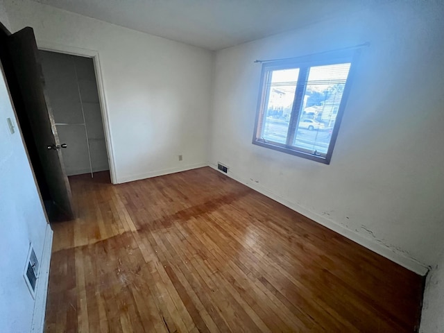 unfurnished bedroom with hardwood / wood-style flooring and a closet