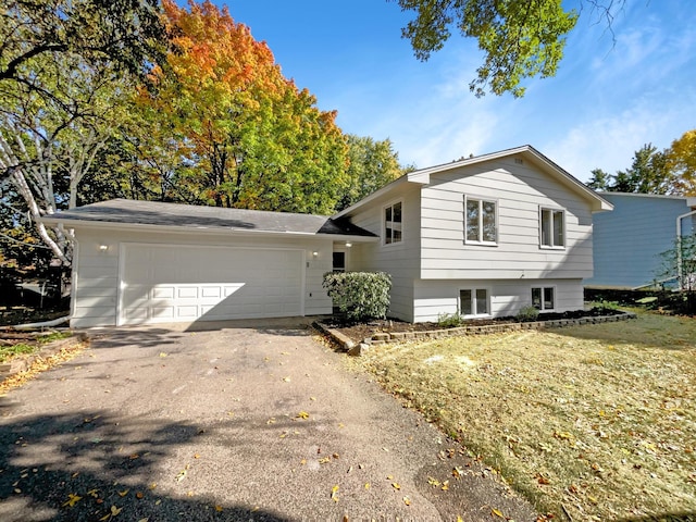 tri-level home featuring a garage and a front lawn