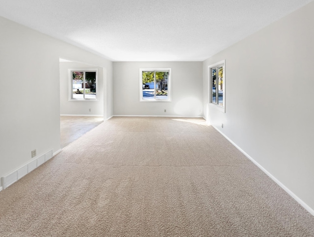 carpeted empty room featuring a textured ceiling