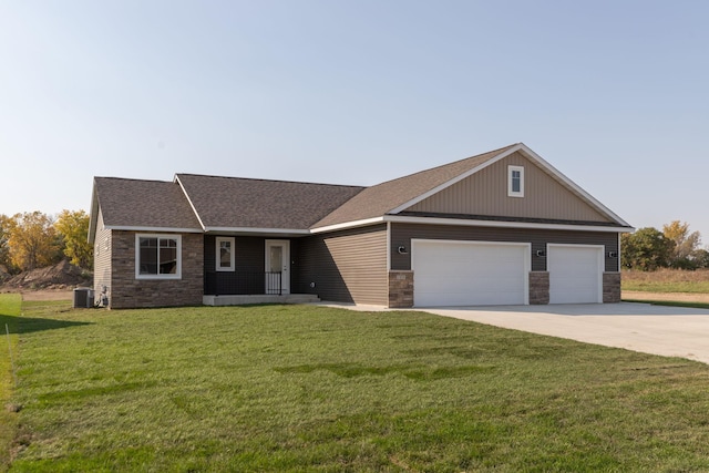 view of front of house with a front lawn, central AC unit, and a garage