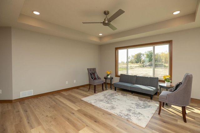 1309 18th St NE, Austin, MN 55912 - sitting room featuring light wood finished floors, a raised ceiling, visible vents, a ceiling fan, and baseboards
