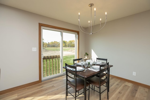 dining area with a notable chandelier, light hardwood / wood-style flooring, and a wealth of natural light