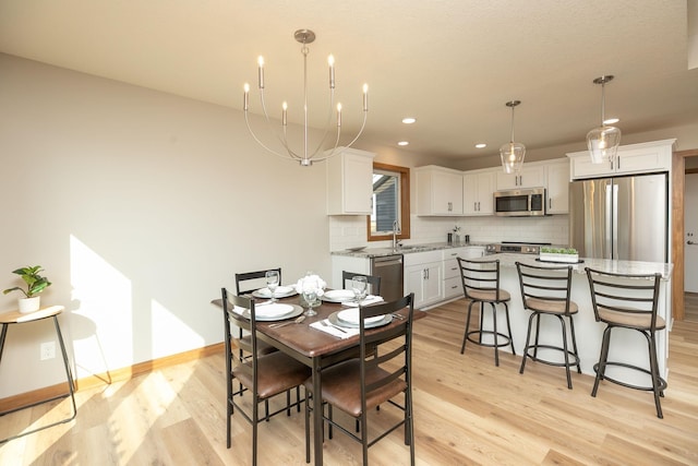 1309 18th St NE, Austin, MN 55912 - dining room featuring baseboards, recessed lighting, a notable chandelier, and light wood-type flooring