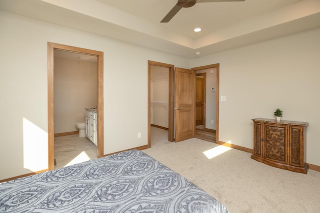 carpeted bedroom with ceiling fan, a spacious closet, a closet, and ensuite bath