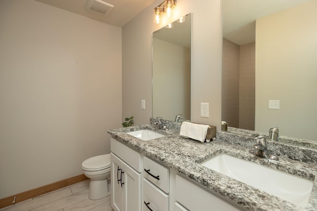 1309 18th St NE, Austin, MN 55912 - bathroom with toilet, a sink, visible vents, and baseboards