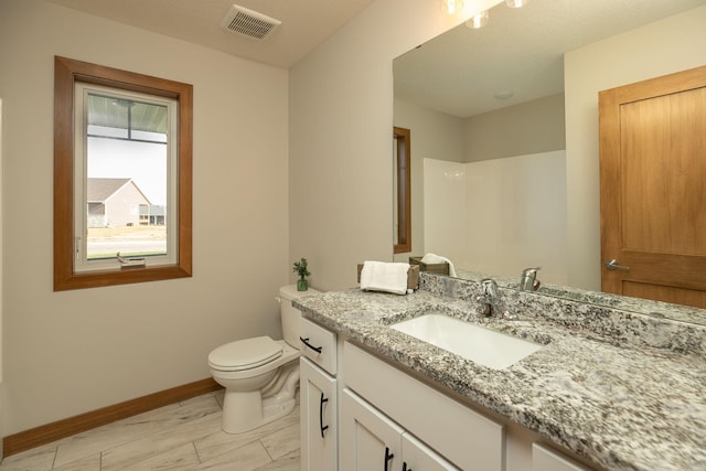 1309 18th St NE, Austin, MN 55912 - bathroom featuring toilet, vanity, visible vents, and baseboards