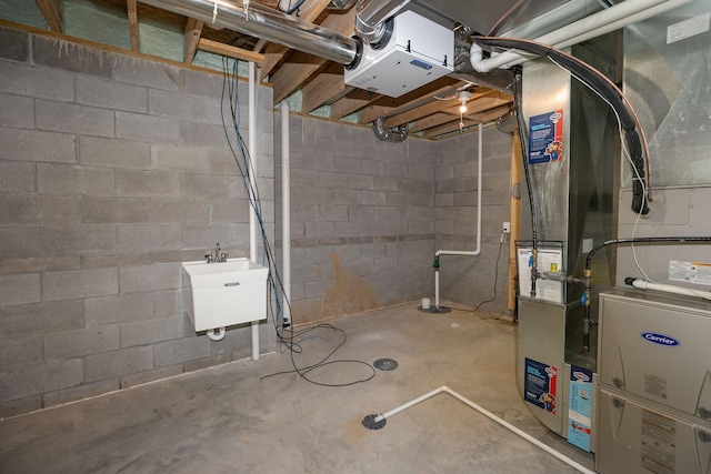 1309 18th St NE, Austin, MN 55912 - unfinished basement featuring concrete block wall, heating unit, and a sink