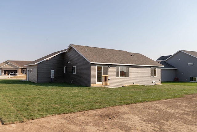 rear view of property featuring a lawn