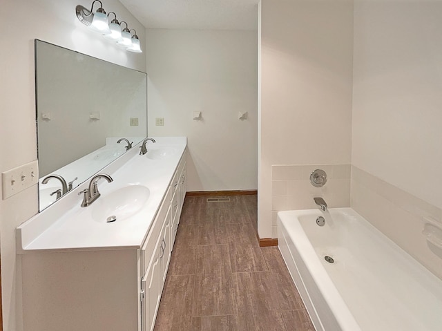 bathroom with hardwood / wood-style flooring, a bathing tub, and vanity