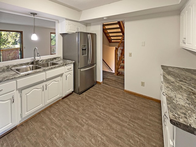 kitchen featuring white cabinets, hanging light fixtures, stainless steel fridge, sink, and a baseboard radiator