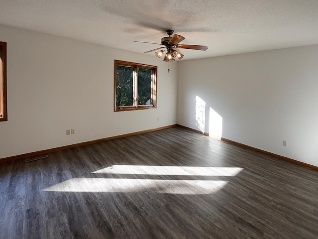 empty room with ceiling fan, dark hardwood / wood-style flooring, and a textured ceiling