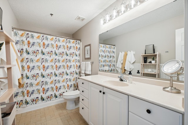 full bathroom with toilet, a textured ceiling, vanity, and shower / bathtub combination with curtain