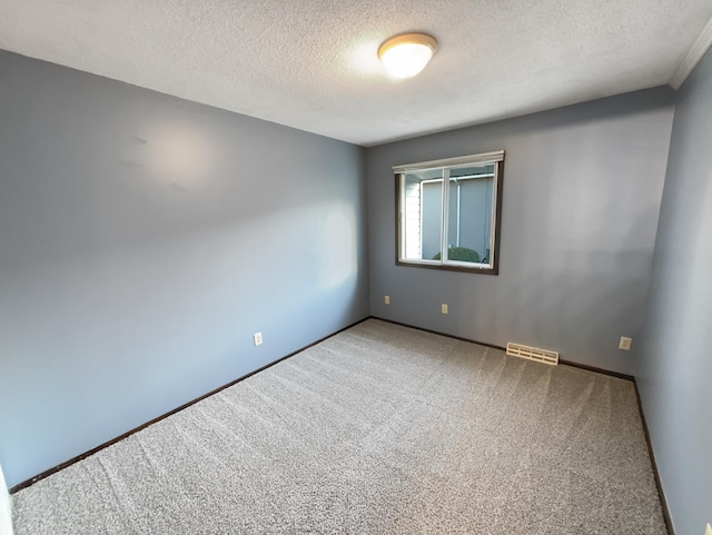 empty room with carpet and a textured ceiling