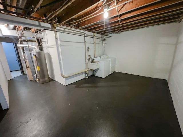 basement featuring gas water heater, washing machine and dryer, and sink