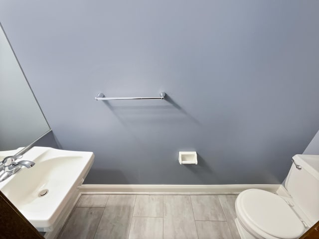 bathroom featuring hardwood / wood-style flooring, sink, and toilet