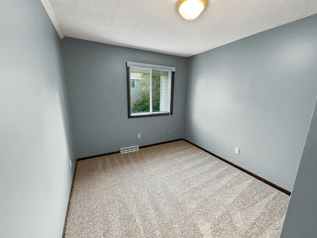 carpeted empty room featuring a textured ceiling