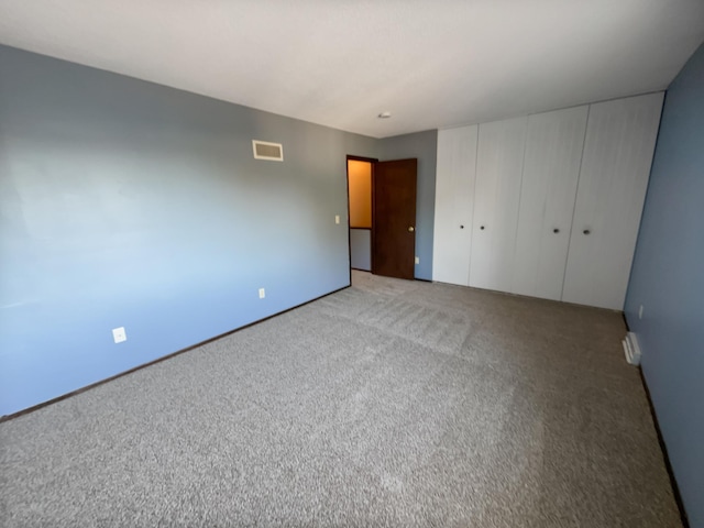 unfurnished bedroom with a closet and carpet flooring