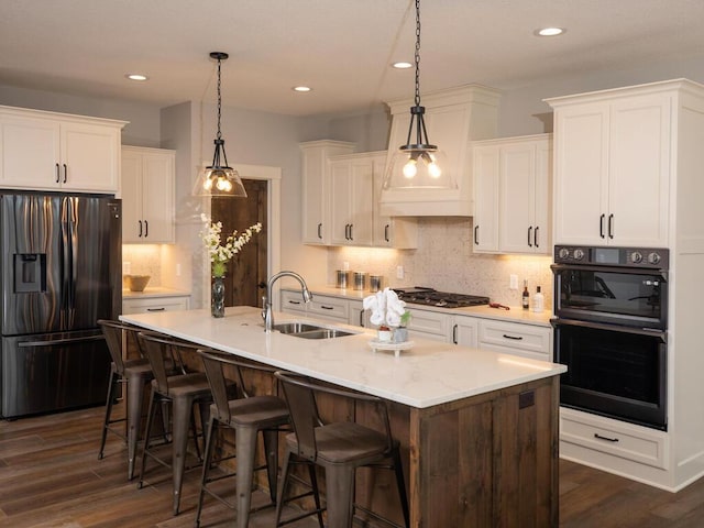 kitchen with a center island with sink, dark hardwood / wood-style floors, and appliances with stainless steel finishes