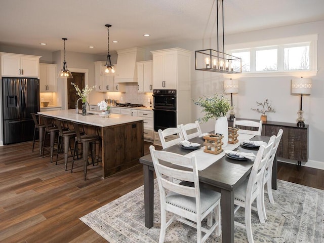 dining space with a notable chandelier, dark hardwood / wood-style floors, and sink