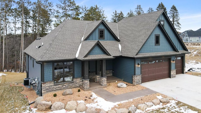 view of front of house with cooling unit, a garage, and covered porch