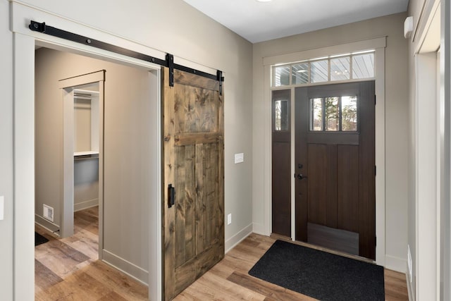 entrance foyer with a barn door and light wood-type flooring