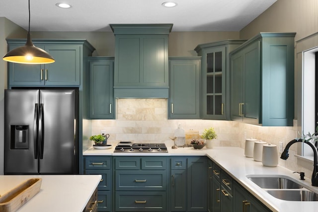 kitchen with stainless steel appliances, hanging light fixtures, sink, and decorative backsplash