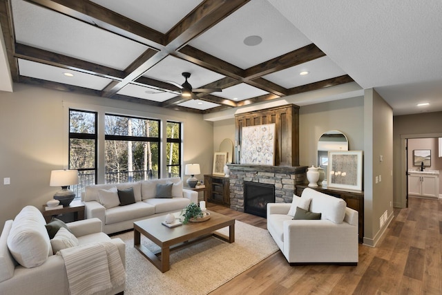 living room with coffered ceiling, beam ceiling, a fireplace, and wood-type flooring