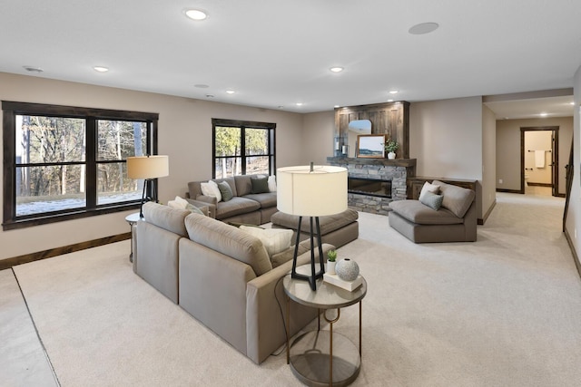 carpeted living room with a stone fireplace