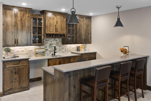 bar featuring tasteful backsplash, sink, and hanging light fixtures