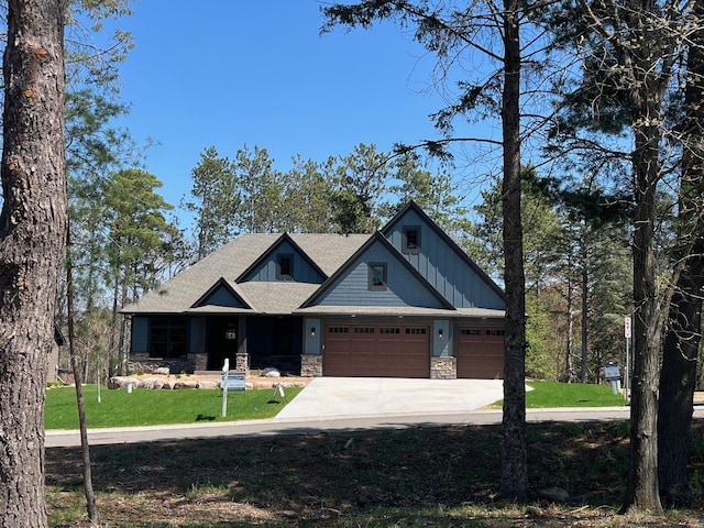 9998 211th Ct N, Forest Lake, MN 55025 - craftsman-style house with stone siding, an attached garage, concrete driveway, a front yard, and roof with shingles