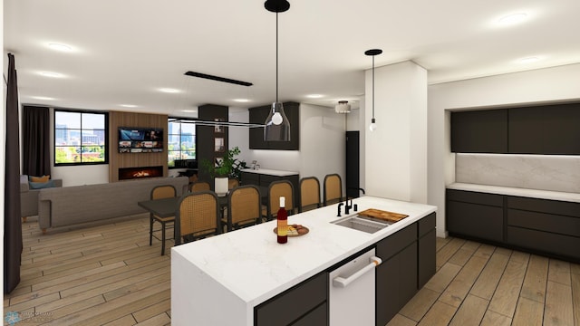 118 Broadway N Unit 702, Fargo, ND 58102 - kitchen featuring light wood-style flooring, light countertops, and an island with sink