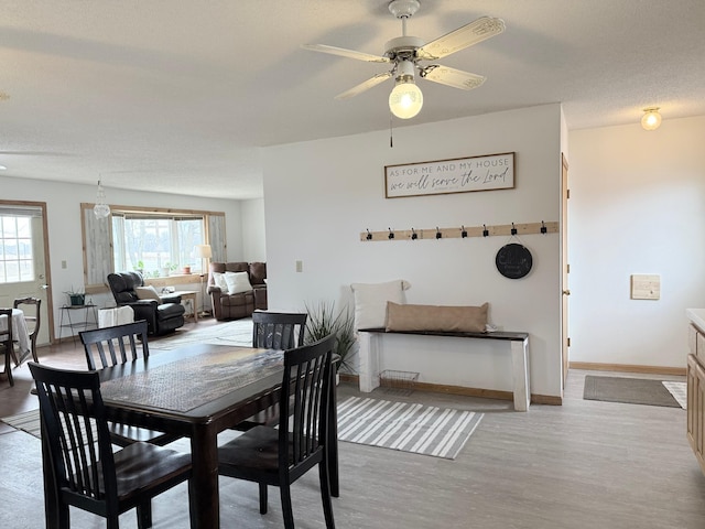 dining space with baseboards, ceiling fan, and wood finished floors