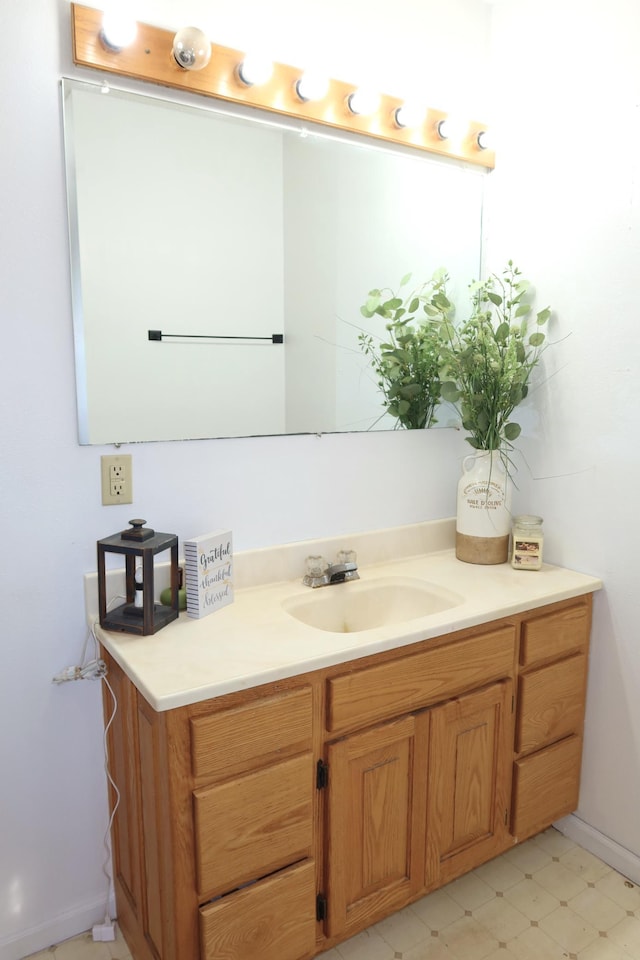 bathroom with tile patterned floors, baseboards, and vanity